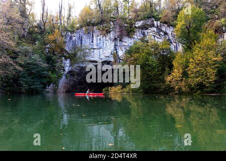 Woman at natural bridge kayaking in flooded forest at Rakov skocjan, Slovenia Stock Photo