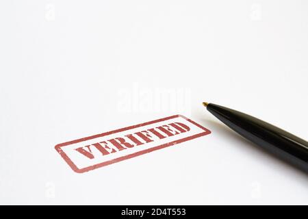 Word Verified in red color and a pen on bright background Stock Photo