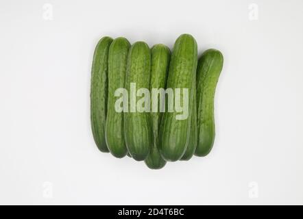 Top down view on isolated pile green raw fresh mini cucumbers on white blank background Stock Photo