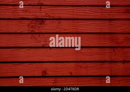 Vermilion red colored horizontal pattern old wooden fence background Stock Photo