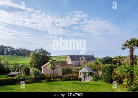 The large tithe barn at the ruins of Abbotsbury Abbey, a former Benedictine monastery in Abbotsbury, Devon, south-east England, seen from Abbey House Stock Photo