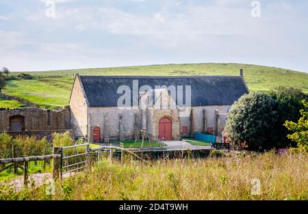 The large tithe barn at the ruins of Abbotsbury Abbey, a former Benedictine monastery in Abbotsbury, Devon, south-east England, seen from Abbey House Stock Photo