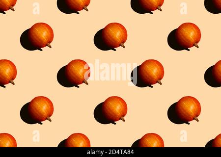 Orange pumpkin fruits on a beige background. Contrast seamless pattern. For backgrounds or packaging. A high resolution. Stock Photo