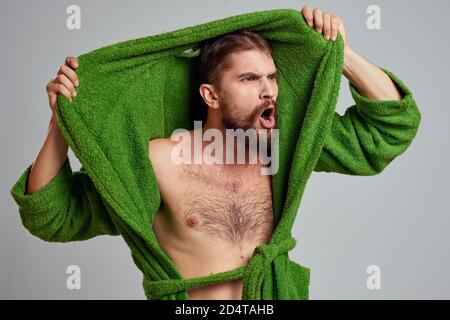Bearded man in green robe cropped view gray background close-up Stock Photo