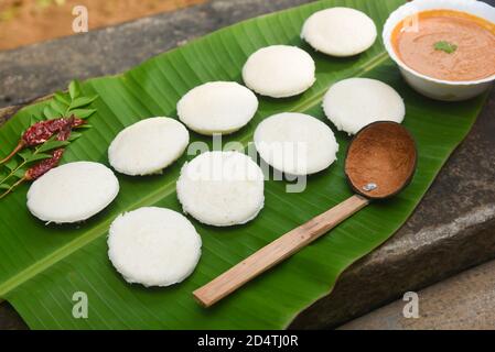 Indian idly served on traditional vegetarian food. Lots of many fresh steamed Indian Idly , Idli rice cake. South Indian breakfast idly sambar Sambhar Stock Photo