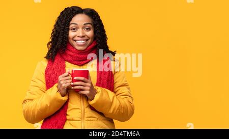African Lady In Jacket Enjoying Coffee Posing On Yellow Background Stock Photo