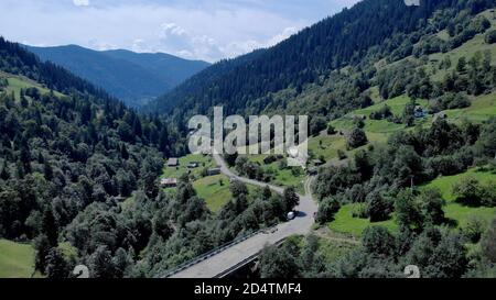 Asphalt road bends through the forests mountains. Stock Photo