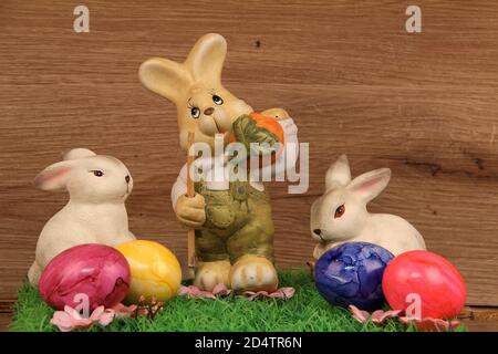 Closeup shot of three easter bunnies figurines on a wooden background Stock Photo
