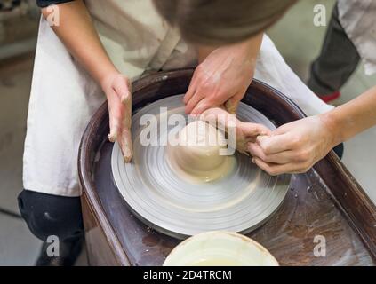 Child potters hands molding clay on wheel at workshop Stock Photo - Alamy