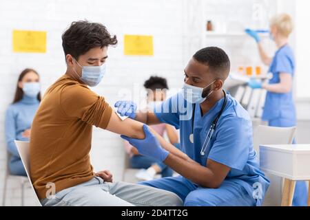 Asian Male Patient Getting Vaccinated Against Coronavirus In Hospital Stock Photo