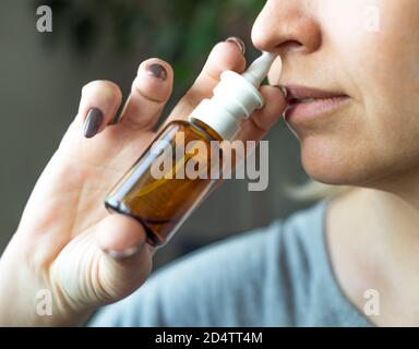 Woman using nasal spray close up. Health care concept. Stock Photo