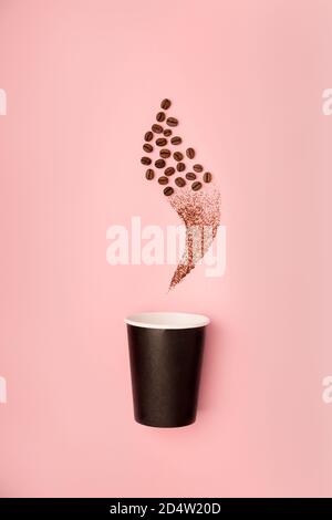 Disposable paper black cup mock up for coffee to go decorated with coffee beans flat lay on pink paper background. Stock Photo