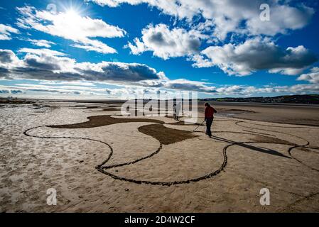 Arnside, Cumbria, UK. 11th Oct, 2020. Lancaster artist Paul Speight's latest creation of sand art at White Creek, Arnside, Cumbria where the unique silt sand enables him to work with three different tones. Tide conditions need to leave the sand dry enough to achieve the contrasting textures but not too dry which makes it too hard to rake. Credit: John Eveson/Alamy Live News Stock Photo