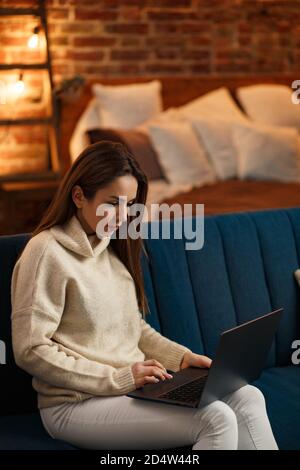 Working from home.Communication online with colleagues and freelancers.Portrait of young female freelancer using laptop and smiling. Concept of young Stock Photo