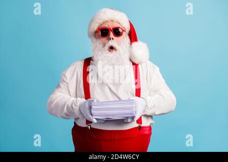 Portrait of his he nice attractive amazed wondered thick white-haired Santa holding in hand pile mail letters wish list December tradition isolated Stock Photo