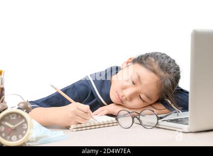 School girl learning online education classes feeling bored and write on notebook isolated on white background, Due to the outbreak of COVID 19 and ed Stock Photo