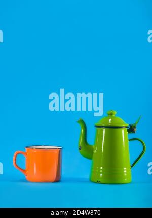 Vintage teacup and orange cup on blue background. Copy space on top Stock Photo