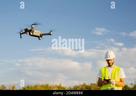 Drone operator man piloting a drone in a rural setting Stock Photo