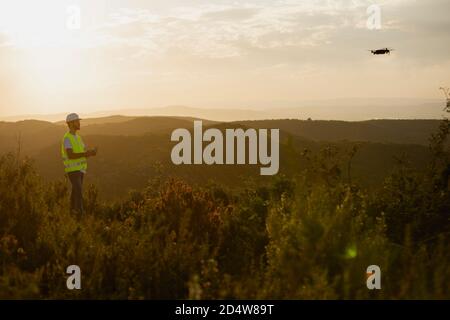 Drone operator man piloting a Drone In A Rural Setting Stock Photo
