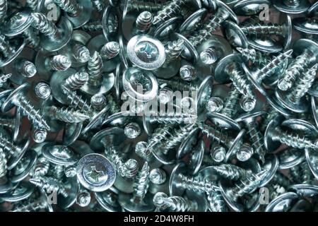 Metallic texture background. Screws and cogs. Tools for fixing and repairing. Stainless steel bolts. Galvanized metal fasteners. Pile of metal screws Stock Photo