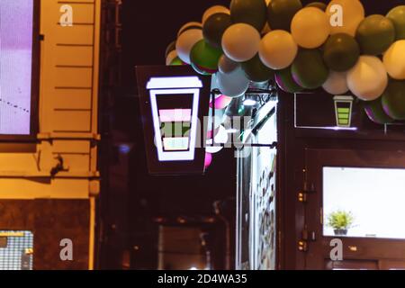 neon icon sign cup coffee glows on the window of the coffee shop at night Stock Photo