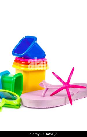 Flip-flops, molds for playing in the sand, sea shells, sun glasses, binoculars isolated on white background. Stock Photo