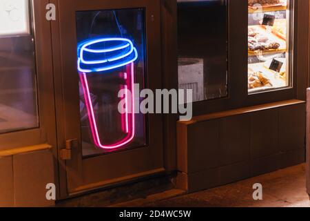 neon icon sign cup coffee glows on the window of the coffee shop at night Stock Photo