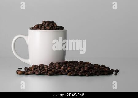 Blank white cup full of coffee beans. White mockup Stock Photo