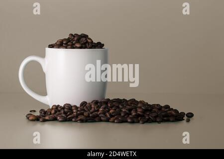 Blank white cup full of coffee beans. White mockup Stock Photo
