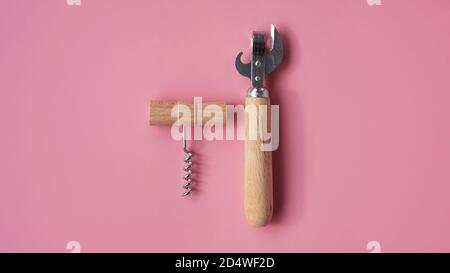 Wooden corkscrews and tin opener on pink background Stock Photo