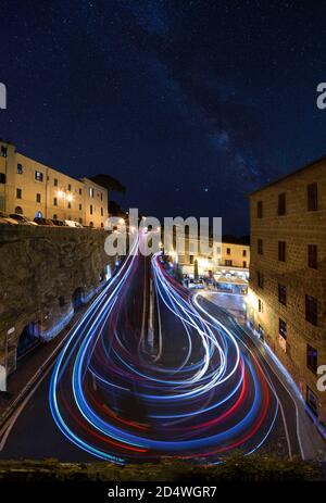 Night View with Light Trails of cars around corner on hillside town Stock Photo