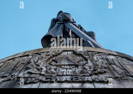 The liberating soviet warrior with the russian word for Glory in the foreground at the Soviet War Memorial (Sowjetisches Ehrenmal) in Treptower Park Stock Photo