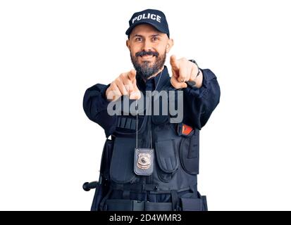 Young handsome man wearing police uniform pointing to you and the camera with fingers, smiling positive and cheerful Stock Photo