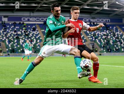 Northern Ireland's Conor McLaughlin (left) and Austria's Christoph Baumgartner battle for the ball during the UEFA Nations League Group 1, League B match at Windsor Park, Belfast. Stock Photo
