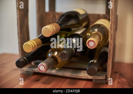 Wine bottles stacked in a vintage wine box. Closeup of an antique case of wine filled with wine bottles. Vintage wine case. Stock Photo