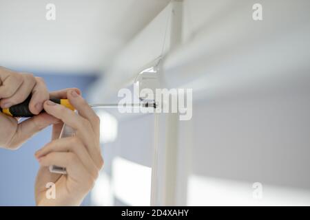 Man installing cassette roller blinds on windows Stock Photo