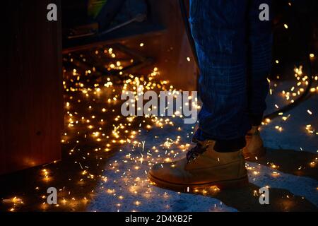 Welding arcs and sparks falling down in repairman workshop Stock Photo