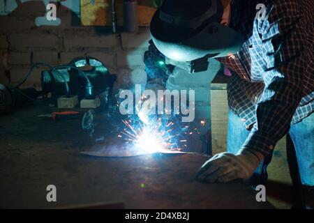 Repair man wearing professional welding mask over head covering