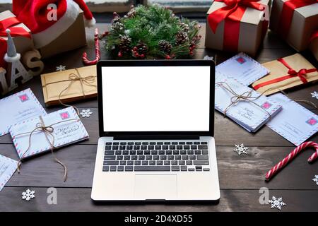 Laptop computer with white mock up screen monitor on Merry Christmas table. Stock Photo