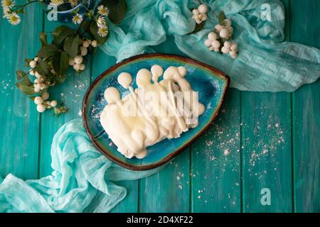 bowl with fresh cottage cheese with sour cream and sugar, in blue oval bowl with grainy cottage cheese on wooden turquoise table, top view Stock Photo