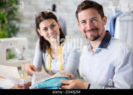 couple of fashion designers working with fabric and clothing sketches Stock Photo