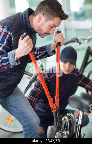 man using bolt croppers on a bicycle Stock Photo