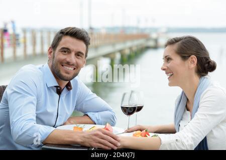 couple having a meal on terrace overlooking a river Stock Photo