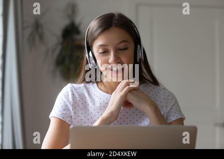 Happy young pretty woman enjoying pleasant conversation at home office. Stock Photo
