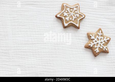 Closeup of star shaped gingerbread cookies with decorative sugar frosting. Christmas cotton muslin fabric mockups scene. Holiday background. Flat lay Stock Photo