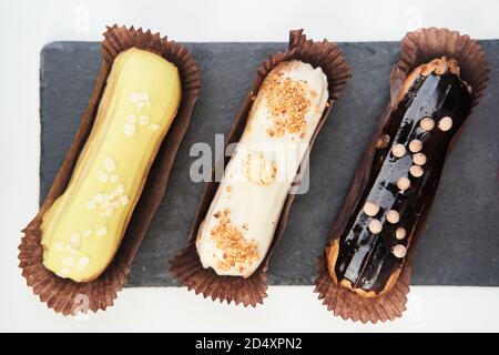 Three eclairs on a black tray top view Stock Photo