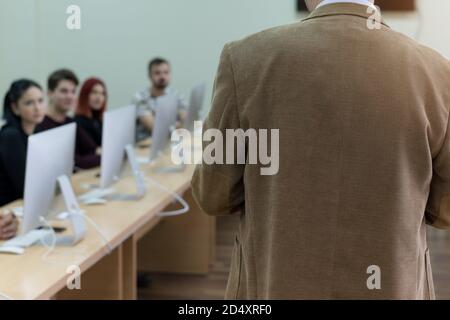 Selective focus on  teacher  while teaching and explaining lessons to students in classroom. Computer lab class, technology and aducation concept. Stock Photo