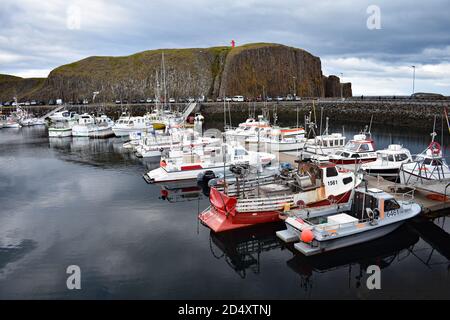 Stykkishólmur Harbour with Sugandisey Island and Lighthouse in the background. Snaefellsnes Peninsular, Iceland. Fishing boats are tied up to the dock. Stock Photo