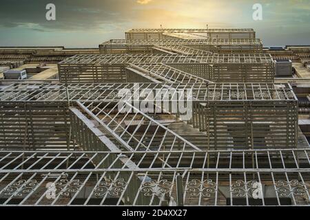 Fire escape stairs mounted to the outside of the buildings, used for emergency exit. Low angle view during sunset Stock Photo