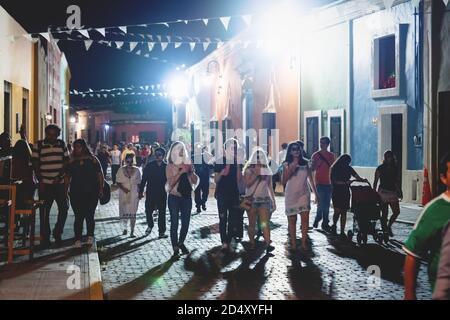 Merida, Mexico - 31 October 2018: Visitors with with catrina make up at the festival for day of the dead walking in a colonial street at night Stock Photo